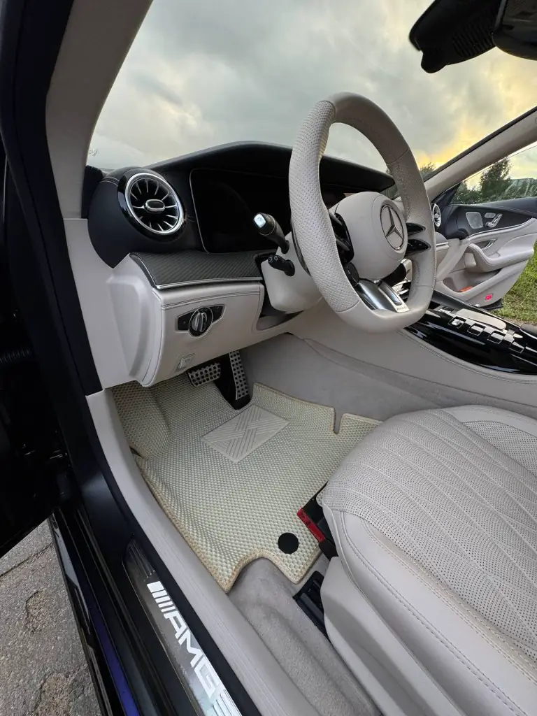 Beżowy dywanik EVA z nakładką pod piętę w Mercedesie AMG, struktura plastra miodu.