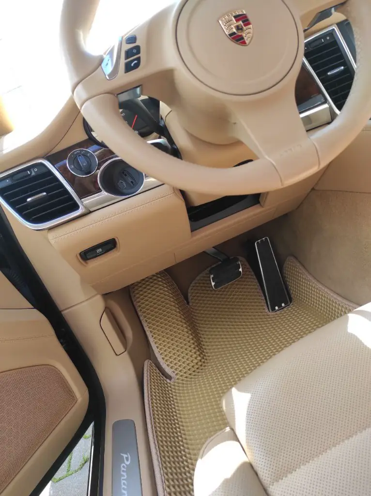 Beżowe dywaniki EVA w Porsche Panamera, struktura plastra miodu, strona kierowcy.