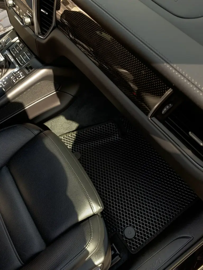 Czarny dywanik EVA o strukturze rombu w Porsche Cayenne, strona pasażera.